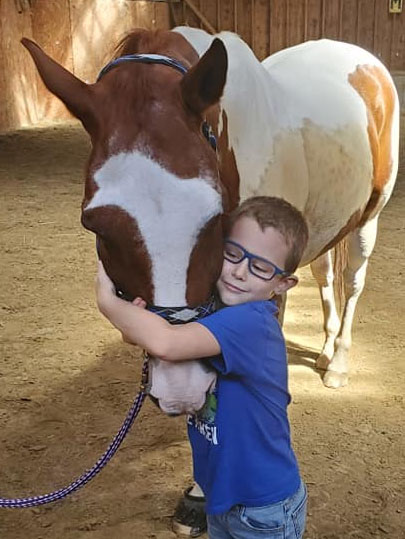 Boy hugging a horse