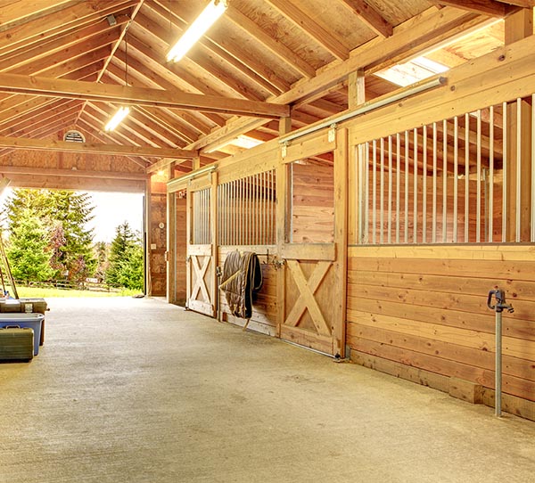 Clean barn with beam ceiling and view of the outside